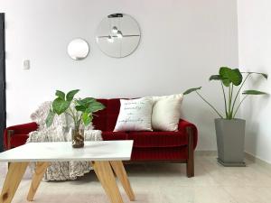 - un salon avec un canapé rouge et une table dans l'établissement Venezia Aparts, à Colón