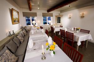 un restaurante con mesas y sofás con flores. en Landhaus Altes Pastorat en Süderende