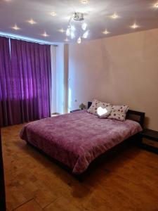 ein Schlafzimmer mit einem Bett mit einer lila Tagesdecke in der Unterkunft Luxury apartment. Луксозен апартамент. MUSI in Welingrad