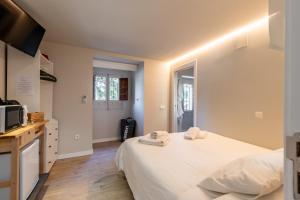 a bedroom with a large white bed and a kitchen at Double Room in ToledoRooms VistaPark in Toledo