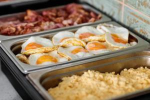 a tray filled with eggs and other food items at Royal Court Hotel in Prague