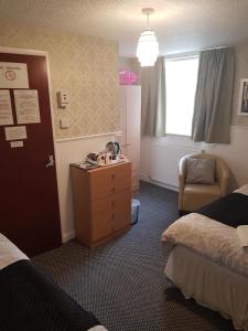 a hotel room with two beds and a desk and a window at Thornhill Blackpool in Blackpool