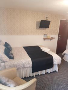 a hotel room with a bed and a chair at Thornhill Blackpool in Blackpool