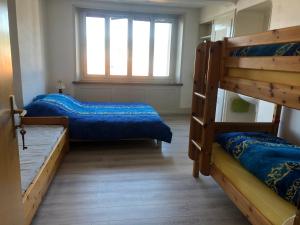 Zimmer mit 2 Etagenbetten und einem Fenster in der Unterkunft Chambres d'Hotes Le Passiflore in Les Brenets