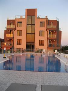 a building with a swimming pool in front of a building at Afrodita Apartments 2 in Sinemorets