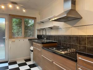 uma cozinha com um lavatório e um fogão forno superior em Tivoli Bungalow em Weston-super-Mare