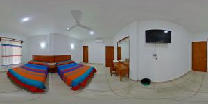 a bedroom with two beds and a flat screen tv at Hotel VidaMar in Puerto Escondido