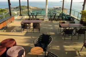 a patio with tables and chairs and the ocean at AnnA Suites Ipanema in Rio de Janeiro