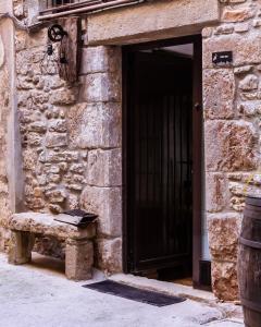 uma porta para um edifício de pedra com um banco à frente em Casa Tato Figuerola d'Orcau em Figuerola de Orcau