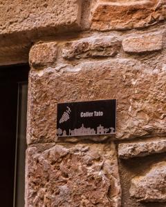 un panneau sur le côté d'un mur de pierre dans l'établissement Casa Tato Figuerola d'Orcau, à Figuerola de Orcau