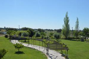 a park with benches and trees in the grass at Tranquilidade Alentejana in São Cristóvão