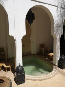 una piscina d'acqua in una stanza in un edificio di Riad Sin a Marrakech