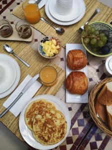 un tavolo ricoperto di piatti di pane e prodotti per la colazione di Riad Sin a Marrakech