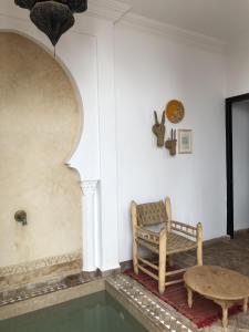 um quarto com um banco e uma mesa e água em Riad Sin em Marrakech