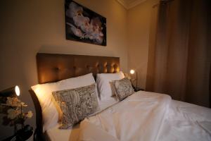 a bedroom with a bed with white sheets and pillows at Salmiya Casa Hotel in Kuwait