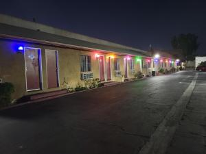 a building with colorful lights on a street at night at Deluxe Motel, Los Angeles Area in Downey