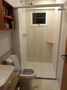 łazienka z prysznicem, toaletą i oknem w obiekcie Apartamento no Salinas Exclusive Resort w mieście Salinópolis