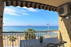een balkon met een tafel en uitzicht op de oceaan bij RANCHOS 3-2 Levante Beach in Benidorm