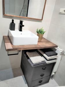 a bathroom with a sink and a counter with towels at Acogedor apartamento en EL VALLE DEL JERTE 1 in Piornal