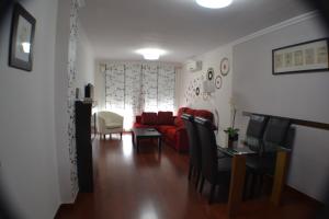 sala de estar con sofá rojo y mesa en Apartamento Acueducto, tres dormitorios y parking gratis, en Mérida