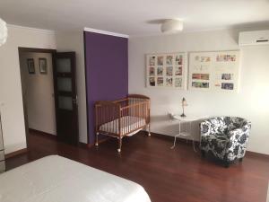 1 dormitorio con cuna, mesa y silla en Apartamento Acueducto, tres dormitorios y parking gratis, en Mérida