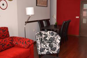 a living room with a chair and a table at Apartamento Acueducto, tres dormitorios y parking gratis in Mérida