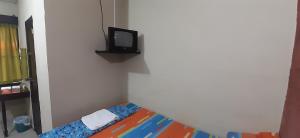 a small room with a bed and a tv on a wall at Bosques del Tibet in Cerro Verde