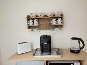 - un comptoir avec une cafetière et des tasses sur un mur dans l'établissement CHARMANTE MAISON PRES DE DIEPPE, à Offranville