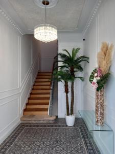 a hallway with stairs and a chandelier and a palm tree at Elvas the Queen Residence in Elvas