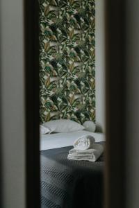 un espejo reflejo de una cama con una toalla en Elvas the Queen Residence, en Elvas
