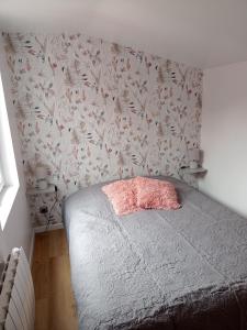 1 dormitorio con 1 cama y papel pintado con motivos florales en CHARMANTE MAISON PRES DE DIEPPE, en Offranville