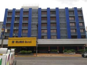 巴拿馬城的住宿－歐洲酒店，蓝色和黄色的建筑,前面有外科旅馆标志