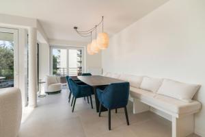 a dining room with a table and blue chairs at The Waves-Luxurious 3bedroom app w big terrace & garage in Ostend