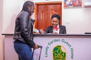 Deux femmes se tenant derrière une table avec une femme dans l'établissement Lovely Garden Guest Home, à Kisumu