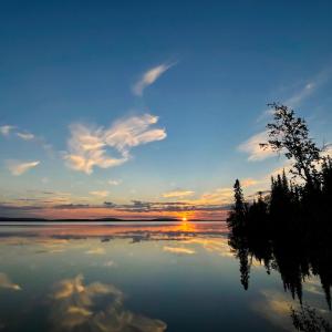 una puesta de sol sobre un lago con el cielo y las nubes en Lapland Dream Villas, en Rauhala