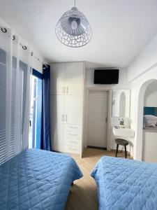 a bedroom with a blue bed and a sink at Marena 1 in Makry Gialos