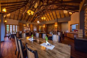 une salle à manger avec une grande table et des chaises en bois dans l'établissement Chimpundu Lodge, à Fort Portal