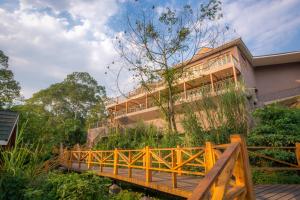a wooden bridge in front of a building at Chimpundu Lodge in Fort Portal