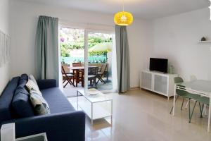 sala de estar con sofá azul y mesa en Apartamento Playa Calera en Valle Gran Rey