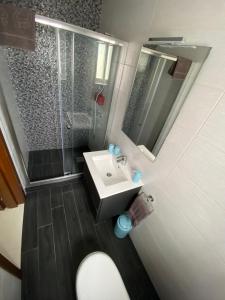 ein Bad mit einem Waschbecken, einer Dusche und einem WC in der Unterkunft Sunshine Apartments Mellieha - modern three bedroom ground floor apartment with yard in Mellieħa