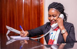 a woman talking on the phone while talking on a telephone at Lovely Garden Guest Home in Kisumu