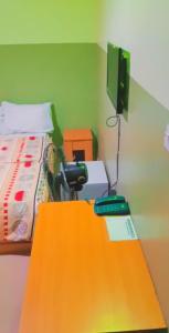 a room with a bed and a table with a television at LARRYDAM HOTEL AND SUITES in Ilesa