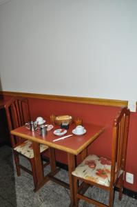 una mesa de madera con 2 sillas y una mesa con comida. en Hotel Casa Blanca - Adults Only, en Río de Janeiro