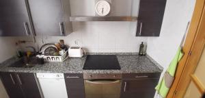 una pequeña cocina con fogones y fregadero en Apartamento ideal Florida, en Vitoria-Gasteiz