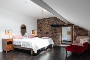 una camera da letto con due letti e un muro di pietra di Chemin de Traverse a Theux