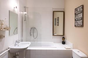 un bagno bianco con vasca e lavandino di Chemin de Traverse a Theux