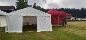 a white tent with a picnic table in a field at Penzion U Dračí skaly in Svojše