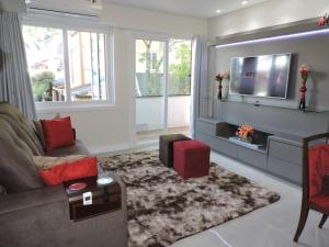sala de estar con sofá y TV en Apartamento Lindo Central, en Gramado