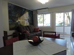 sala de estar con sofá y mesa en Apartamento Lindo Central, en Gramado