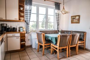 eine Küche mit einem Tisch und Stühlen in der Unterkunft Gästehaus Meiwes in Delbrück